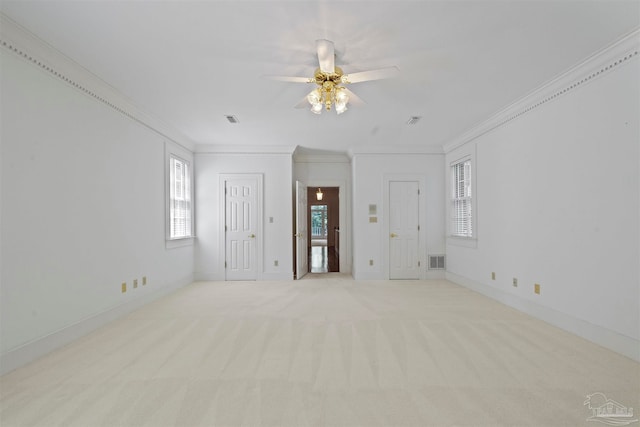 unfurnished room featuring ceiling fan, light colored carpet, and crown molding