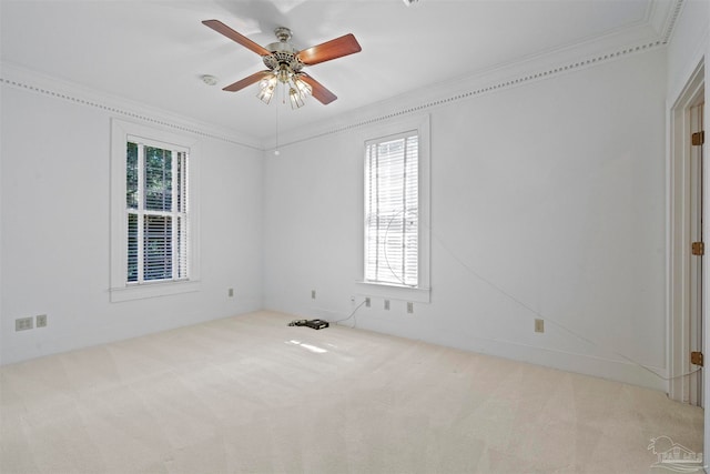 spare room with ornamental molding, ceiling fan, and light colored carpet