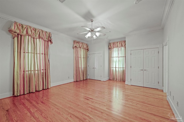 empty room featuring light wood-type flooring, crown molding, and ceiling fan