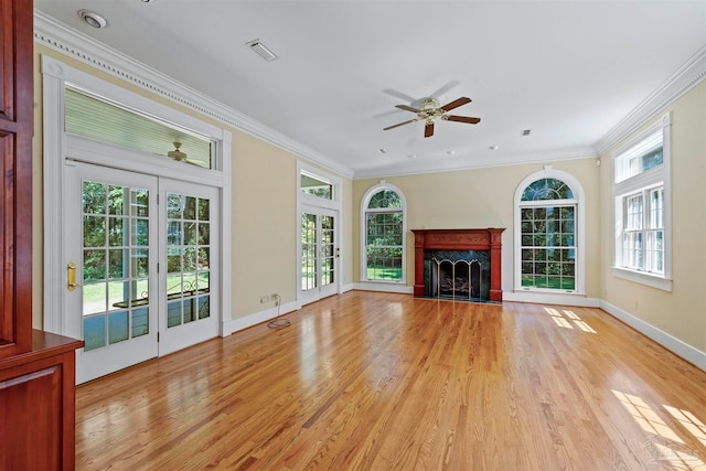 unfurnished living room featuring light hardwood / wood-style floors, a fireplace, ceiling fan, and a wealth of natural light