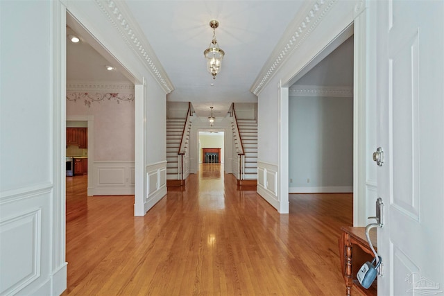 foyer entrance featuring crown molding and light hardwood / wood-style flooring