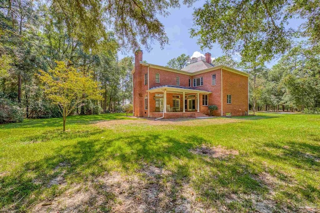 rear view of property with a lawn and a patio area