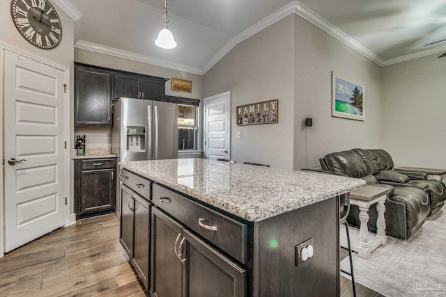 kitchen with a kitchen island, hanging light fixtures, hardwood / wood-style floors, stainless steel fridge, and vaulted ceiling