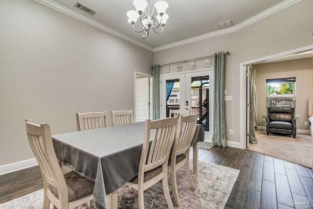 dining area with french doors, crown molding, dark hardwood / wood-style flooring, and an inviting chandelier