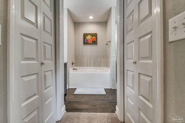 bathroom with a tub and wood-type flooring