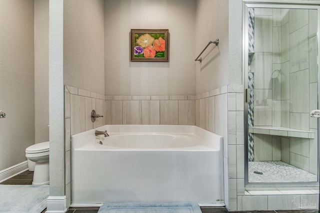 bathroom featuring toilet and separate shower and tub