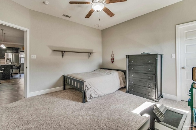 bedroom with stainless steel fridge with ice dispenser, wood-type flooring, and ceiling fan