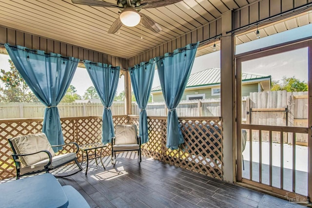 sunroom with ceiling fan and wooden ceiling