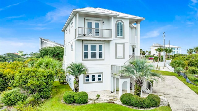 view of front of property with a balcony and a front lawn