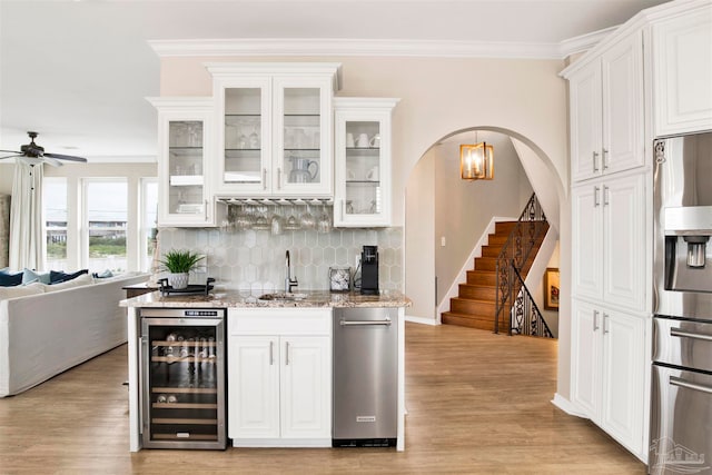 bar featuring white cabinets, backsplash, light hardwood / wood-style flooring, stainless steel fridge, and wine cooler