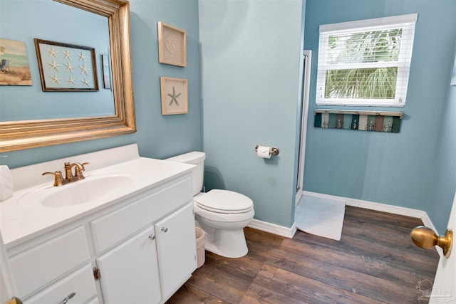 bathroom with vanity, toilet, and hardwood / wood-style flooring