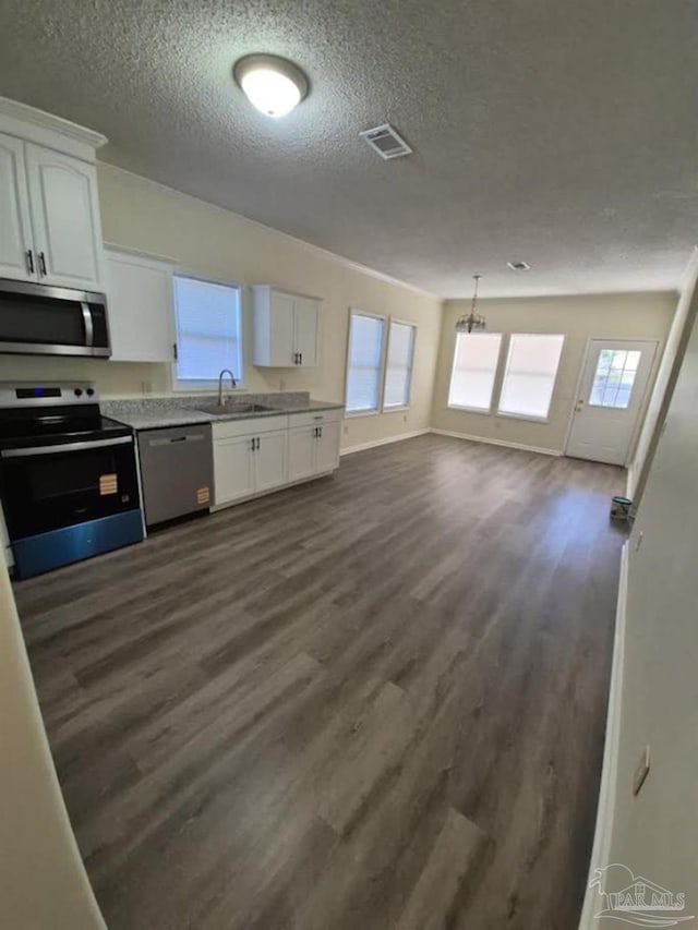 2008 Augusta Ave, Pensacola, FL 32507 - kitchen with stainless steel appliances, dark wood-style floors, white cabinetry, a textured ceiling, and light countertops