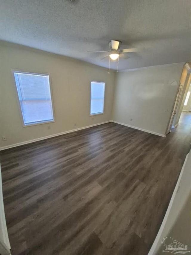 2008 Augusta Ave, Pensacola, FL 32507 - spare room featuring a textured ceiling, dark wood-style floors, baseboards, and a ceiling fan