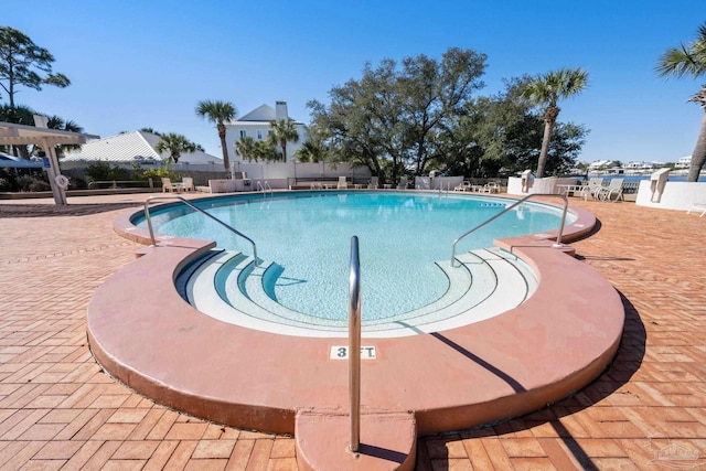 pool with a patio and fence