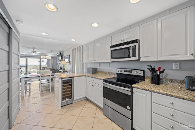 kitchen with white cabinetry, recessed lighting, beverage cooler, and appliances with stainless steel finishes