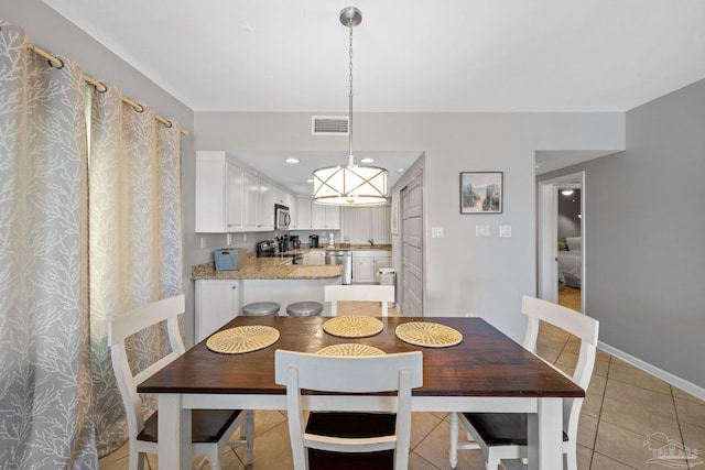 dining area with visible vents, baseboards, an inviting chandelier, and light tile patterned flooring