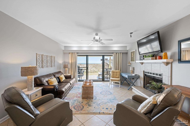 living room with tile patterned floors, a ceiling fan, and a tile fireplace