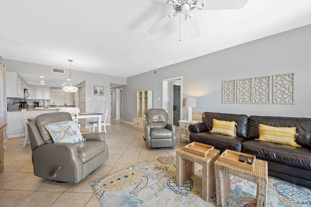 living area with light tile patterned floors, a ceiling fan, visible vents, and baseboards