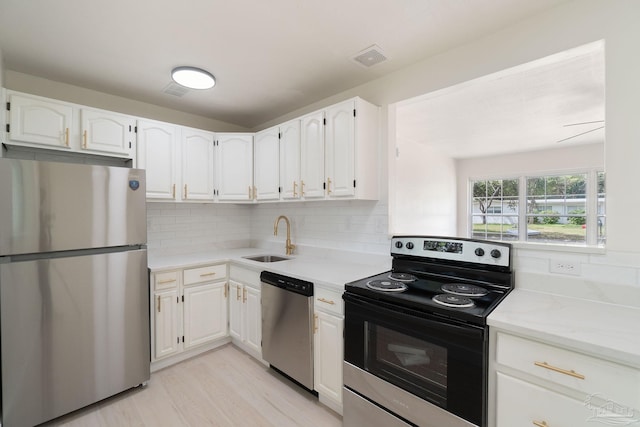 4514 Florelle Way, Pensacola, FL 32505 - kitchen featuring decorative backsplash, white cabinetry, a sink, and appliances with stainless steel finishes