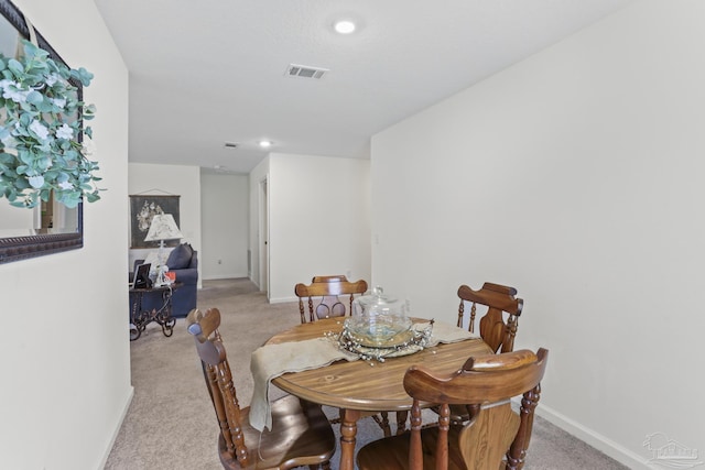 dining room with light carpet, recessed lighting, visible vents, and baseboards