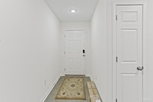 doorway featuring wood finished floors and baseboards