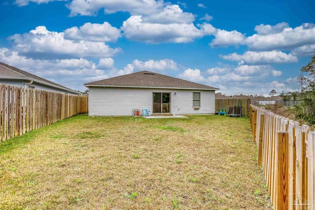 back of house featuring a fenced backyard and a lawn