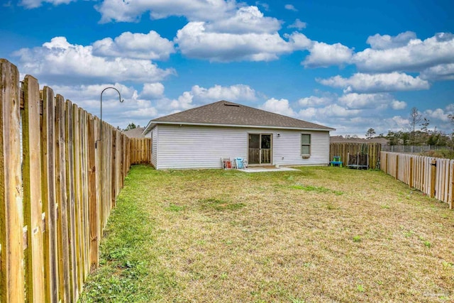 back of house featuring a fenced backyard and a yard