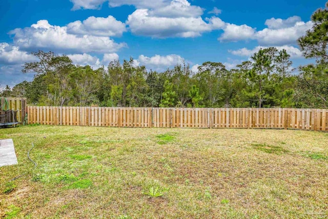 view of yard featuring a fenced backyard and a trampoline