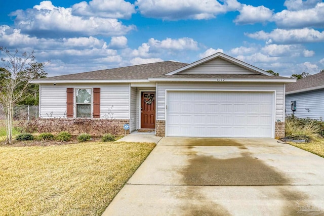 single story home featuring driveway, a front lawn, an attached garage, and brick siding