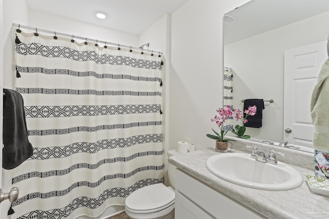 full bathroom featuring a shower with curtain, vanity, and toilet