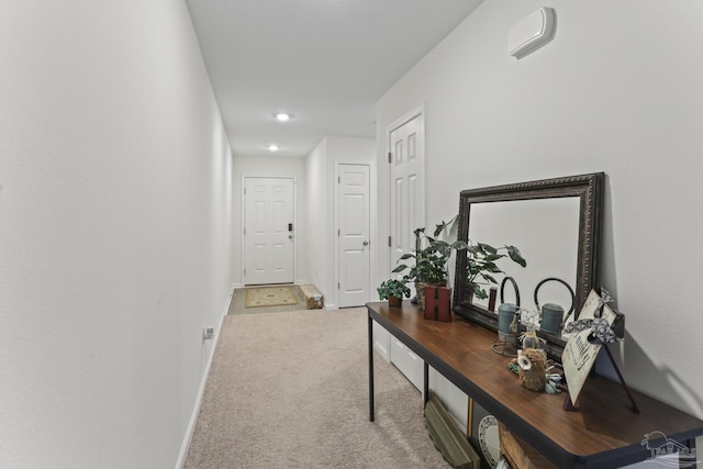 hallway featuring carpet and baseboards