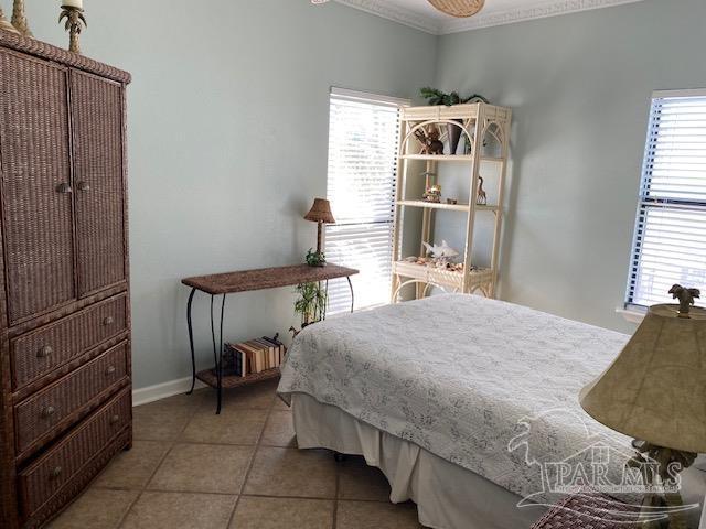 bedroom featuring light tile patterned floors and ornamental molding