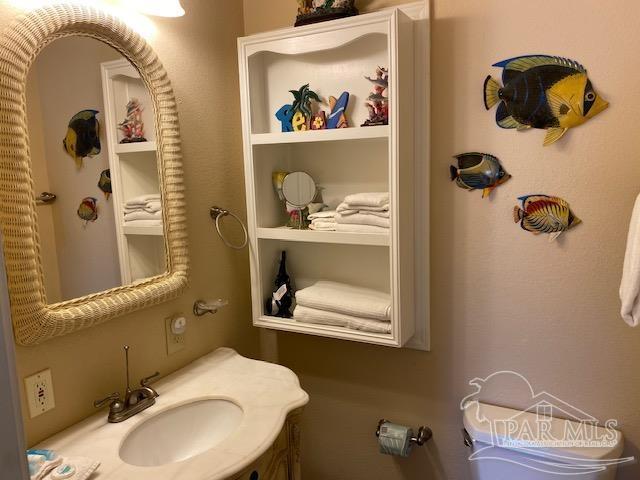 bathroom with toilet, sink, and built in features