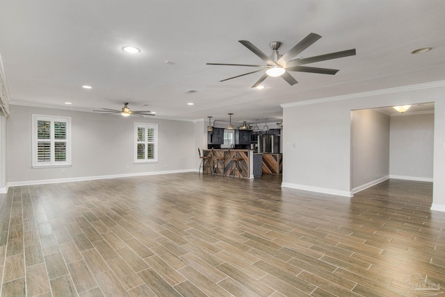 unfurnished living room featuring ornamental molding and ceiling fan