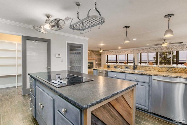 kitchen with hanging light fixtures, black electric stovetop, sink, and stainless steel dishwasher