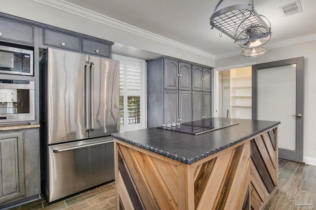 kitchen featuring ornamental molding, appliances with stainless steel finishes, and a kitchen island