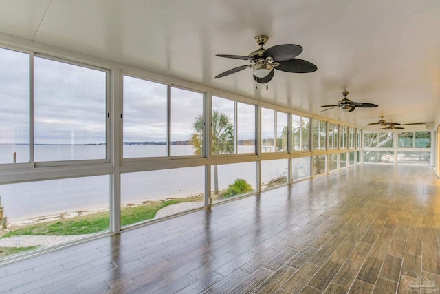 unfurnished sunroom featuring a water view and a wealth of natural light