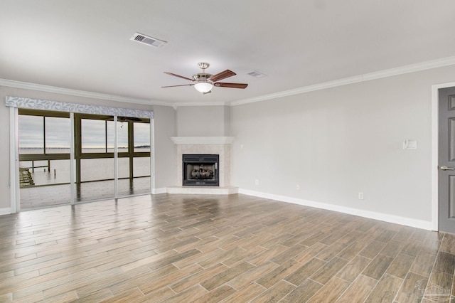 unfurnished living room featuring a water view, ceiling fan, ornamental molding, and a fireplace