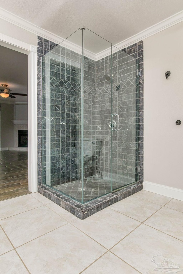 bathroom with a tiled fireplace, tile patterned flooring, and crown molding