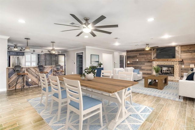 dining area featuring crown molding, ceiling fan, and wood walls