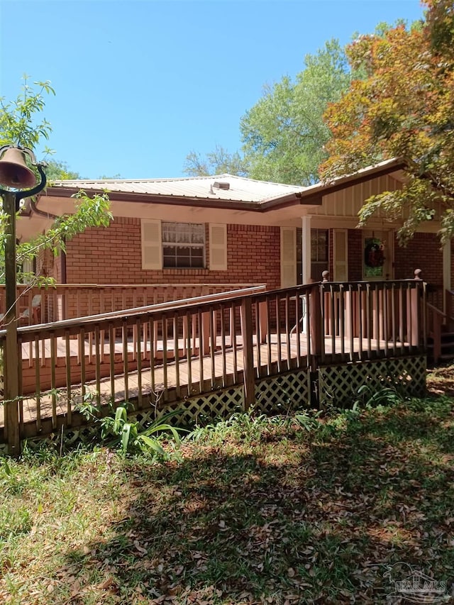 4801 Berryhill Rd, Milton, FL 32570 - back of property with brick siding, a deck, and metal roof