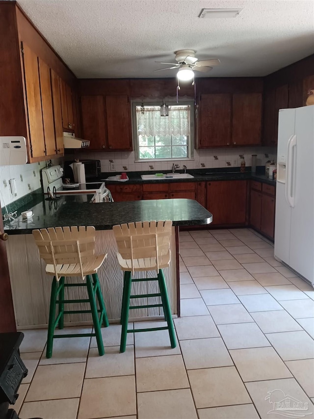 4801 Berryhill Rd, Milton, FL 32570 - kitchen featuring a peninsula, a sink, dark countertops, white appliances, and range hood