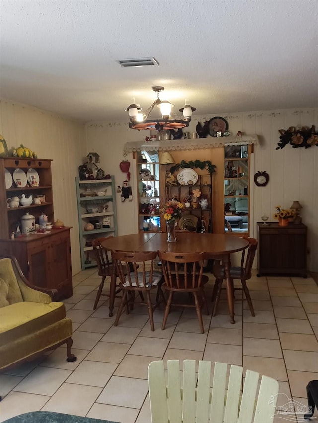 4801 Berryhill Rd, Milton, FL 32570 - dining area featuring light tile patterned flooring, a textured ceiling, visible vents, and a notable chandelier