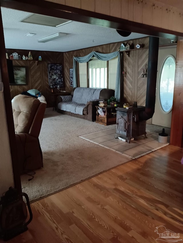 4801 Berryhill Rd, Milton, FL 32570 - living room with wood walls, wood finished floors, a wood stove, and visible vents