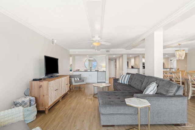 living room featuring crown molding, light hardwood / wood-style flooring, and ceiling fan with notable chandelier