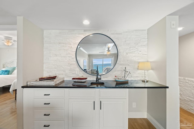 bathroom with decorative backsplash, hardwood / wood-style floors, vanity, and ceiling fan