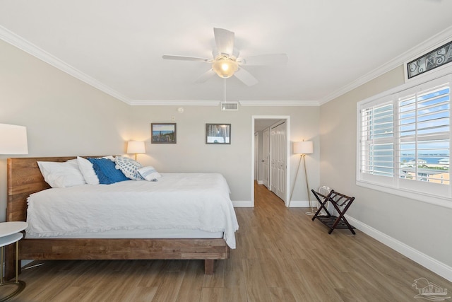 bedroom with ceiling fan, hardwood / wood-style flooring, and ornamental molding