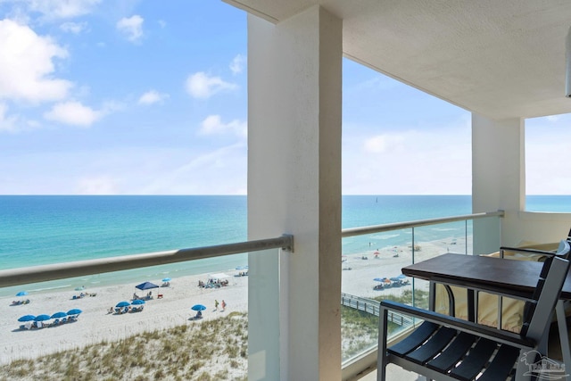 balcony featuring a water view and a beach view