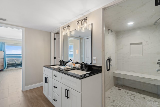 bathroom featuring a healthy amount of sunlight, vanity, a shower with door, and hardwood / wood-style floors