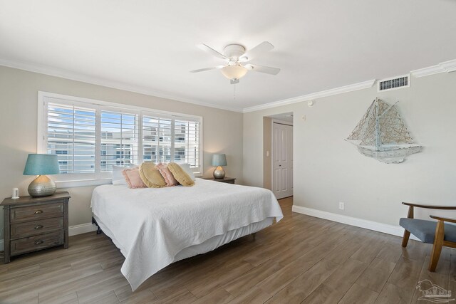 bedroom featuring hardwood / wood-style flooring, ornamental molding, and ceiling fan